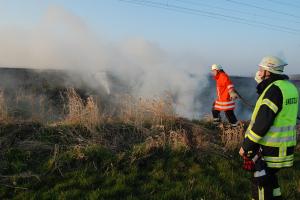 Einsatzkräfte der Freiwilligen Feuerwehren Oyten und Nassen löschen die Brandstellen entlang der Bahnstrecke